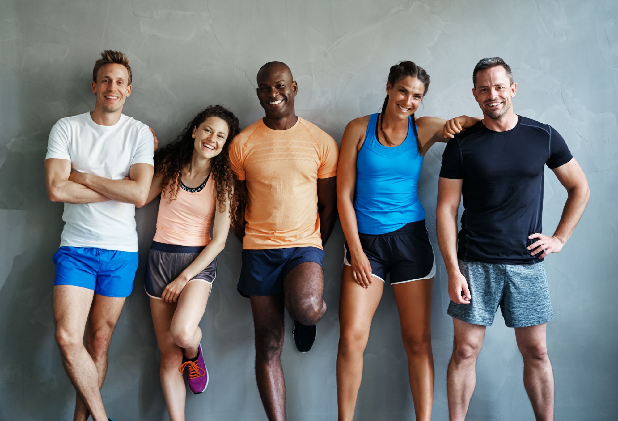 A group of fitness friends smiling and preparing for a workout